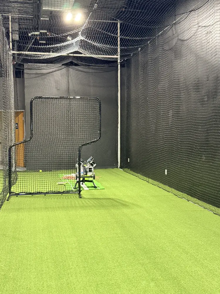 Looking down a tunnel toward the pitching machine and screen